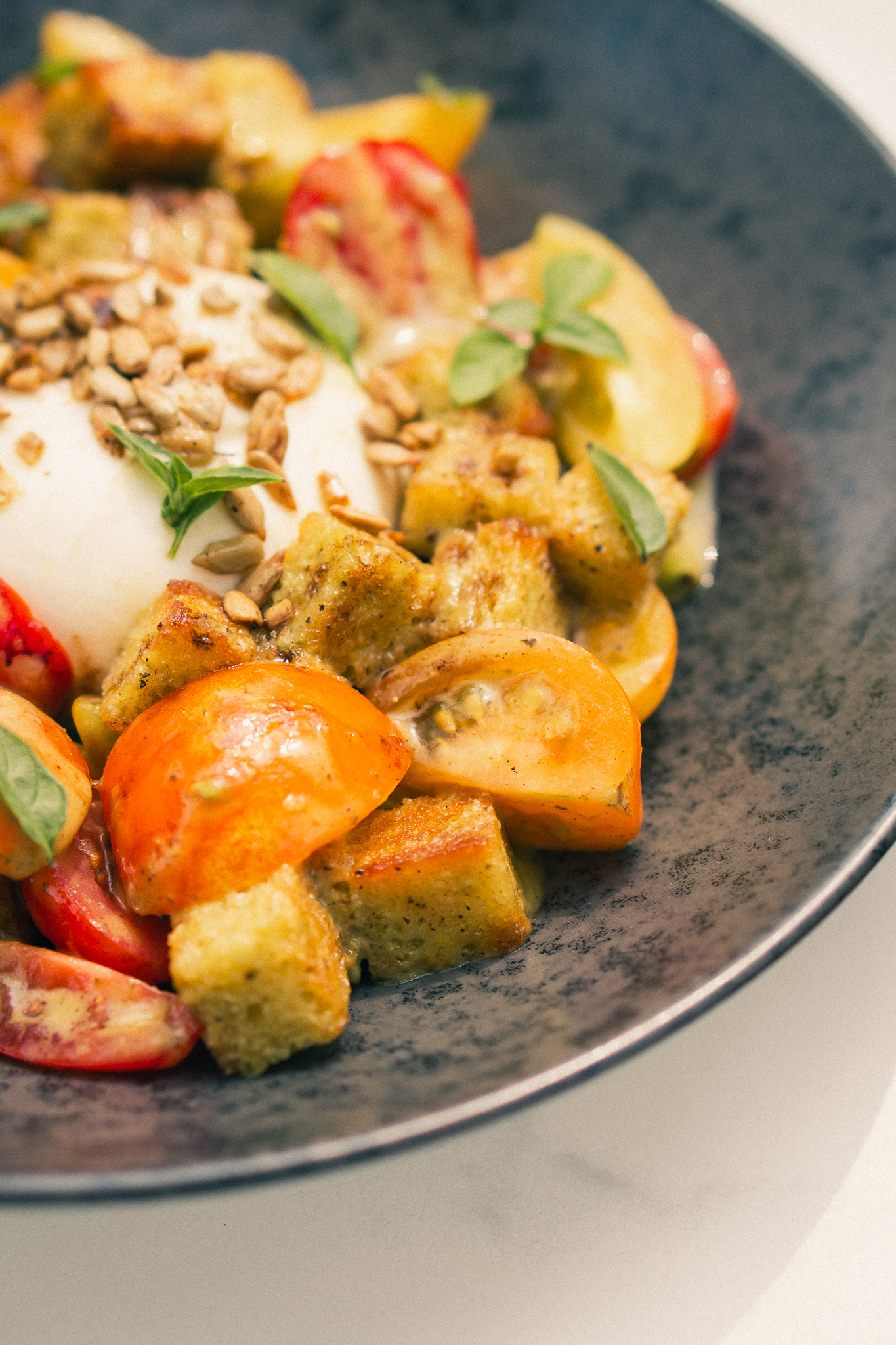 Burrata with heirloom tomatoes, garden basil and sunflower seeds at Glasshouse Kitchen in Research Triangle Park